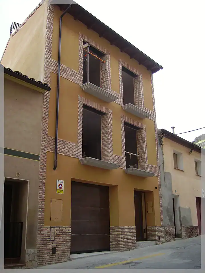 Casa unifamiliar moderna en Monzón con fachada de ladrillo y ventanas amplias.